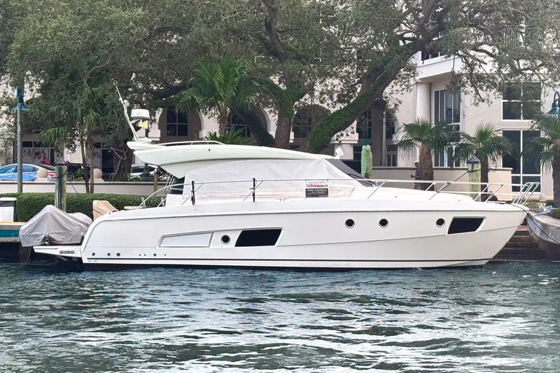 Fly-away Yacht Photos Pics 2015 Bavaria 420 Virtess Coupe yacht docked by waterfront with lush greenery.