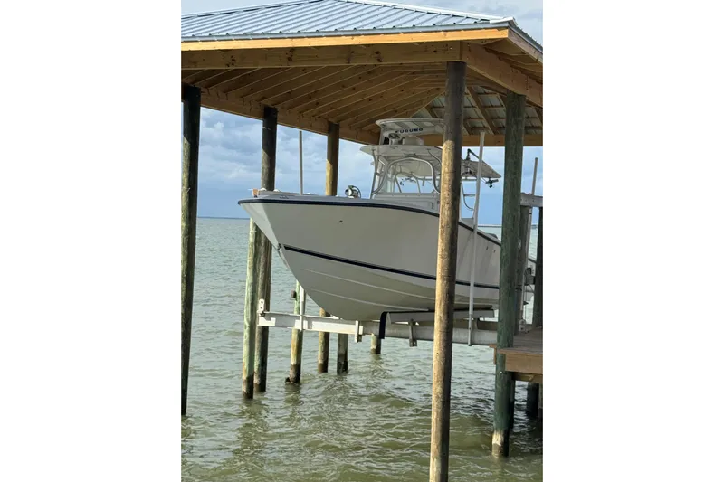  Yacht Photos Pics 2006 SeaVee 34 CC boat on lift under wooden dock shelter.