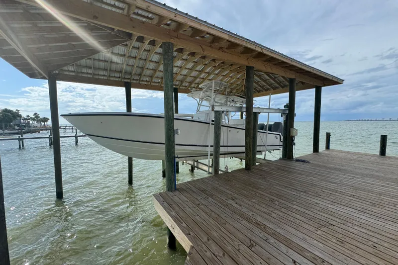  Yacht Photos Pics 2006 SeaVee 34 CC boat on lift under wooden dock shelter by the sea.