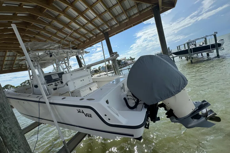  Yacht Photos Pics 2006 SeaVee 34 CC boat docked under a wooden canopy by the water.