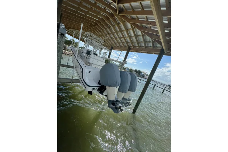  Yacht Photos Pics 2006 SeaVee 34 CC boat docked under a wooden canopy, featuring twin outboard motors.