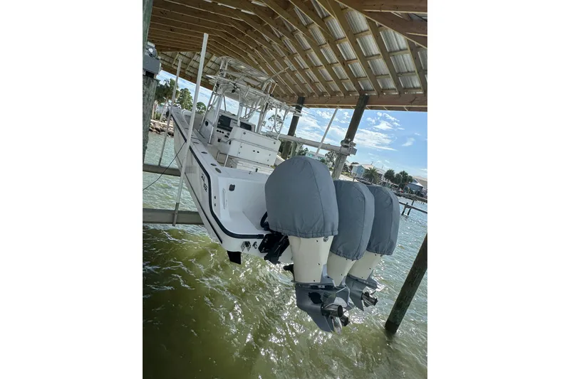  Yacht Photos Pics 2006 SeaVee 34 CC boat with triple outboard engines, docked under a wooden canopy.