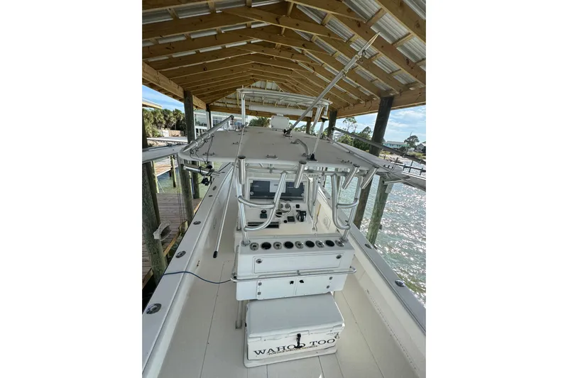  Yacht Photos Pics 2006 SeaVee 34 CC boat docked under a wooden canopy, featuring a central console.