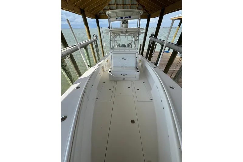  Yacht Photos Pics 2006 SeaVee 34 CC boat docked under a wooden shelter by the water.