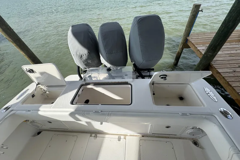  Yacht Photos Pics 2006 SeaVee 34 CC boat with open storage compartments, docked by the water.