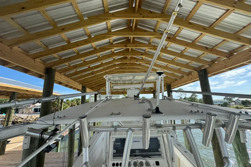  Yacht Photos Pics 2006 SeaVee 34 CC boat docked under wooden shelter with fishing rod holders.