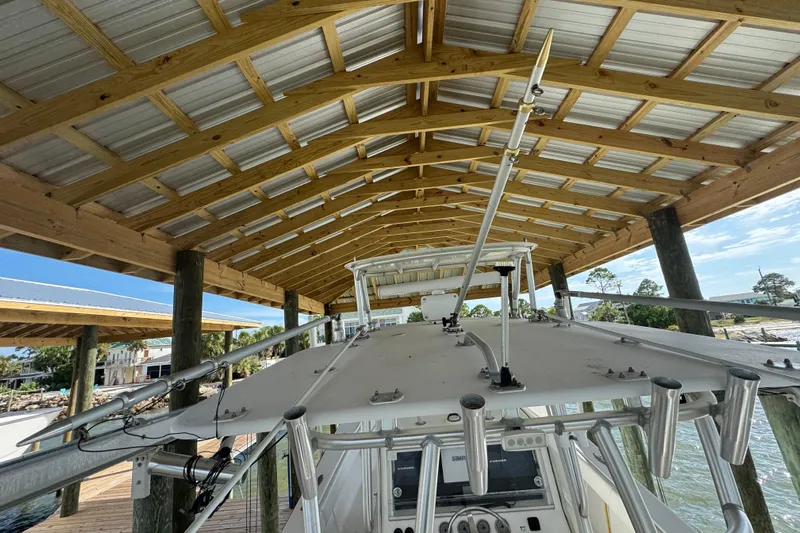  Yacht Photos Pics 2006 SeaVee 34 CC boat under wooden dock shelter, showcasing fishing rod holders.