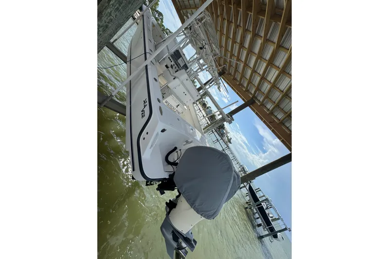  Yacht Photos Pics 2006 SeaVee 34 CC boat docked under a wooden canopy, featuring an outboard motor.