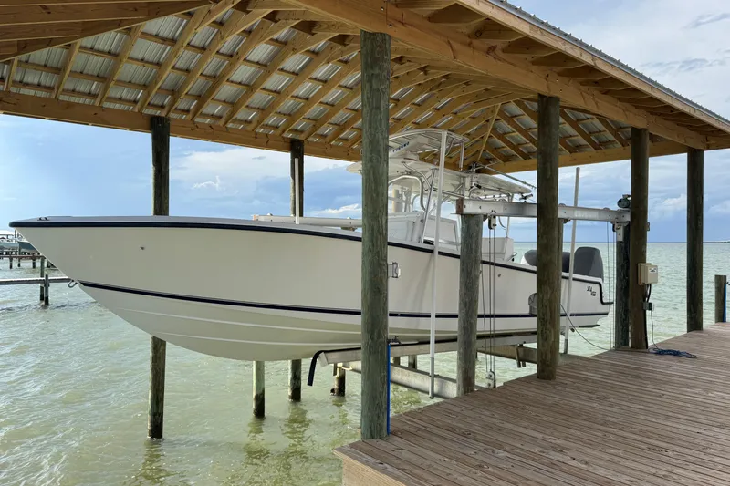  Yacht Photos Pics 2006 SeaVee 34 CC boat docked under a wooden shelter by the water.