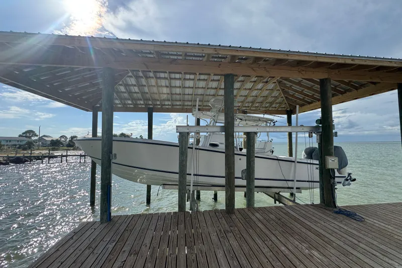  Yacht Photos Pics 2006 SeaVee 34 CC boat docked under a wooden shelter by the water.