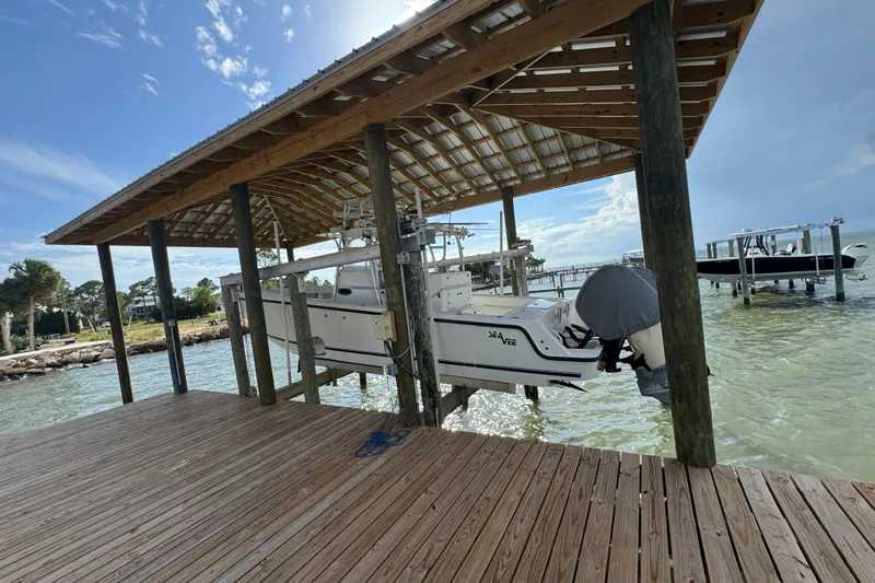  Yacht Photos Pics 2006 SeaVee 34 CC boat docked under a wooden shelter by the water.