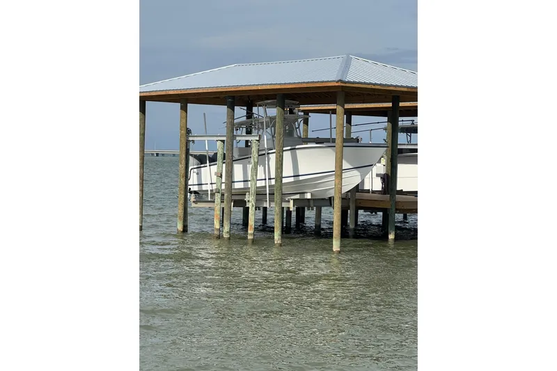  Yacht Photos Pics 2006 SeaVee 34 CC boat docked under a wooden shelter on the water.