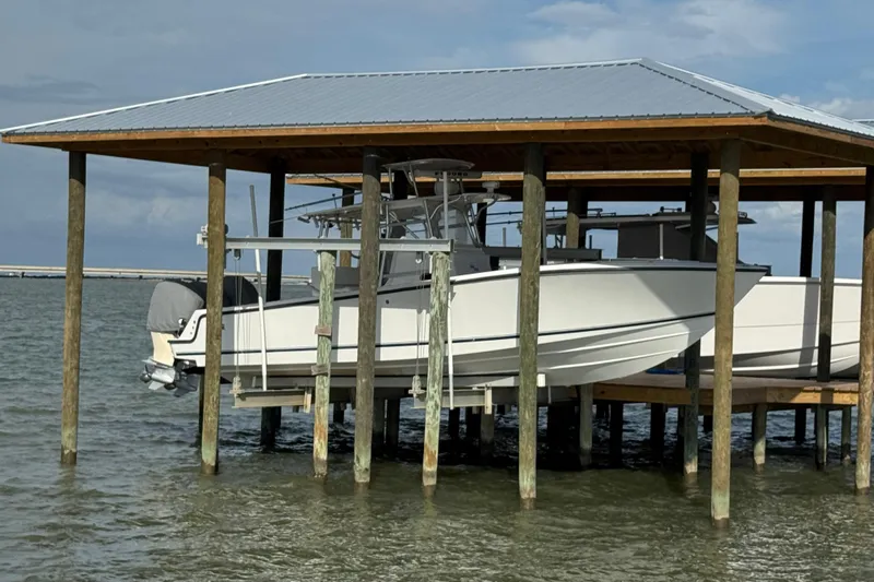  Yacht Photos Pics 2006 SeaVee 34 CC boat docked under a wooden shelter on the water.