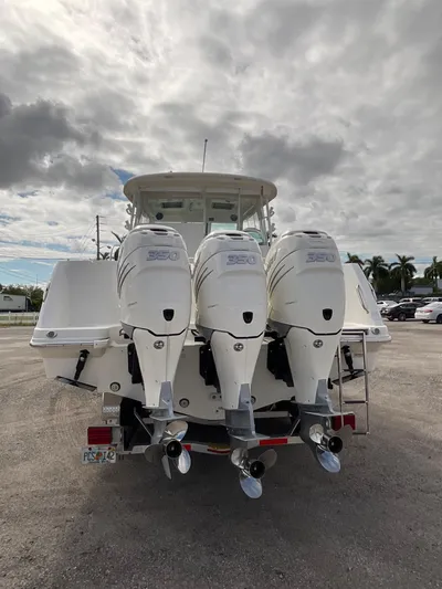  Yacht Photos Pics 2019 Boston Whaler 345 Conquest with triple outboard engines, parked on a cloudy day.