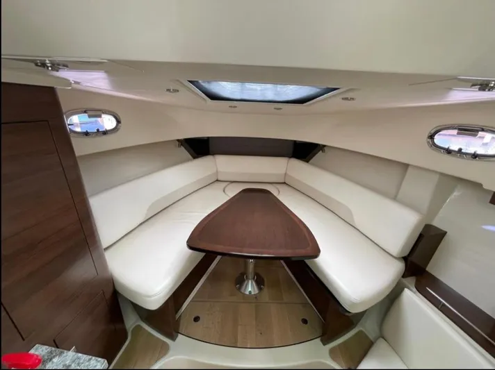  Yacht Photos Pics 2019 Boston Whaler 345 Conquest cabin interior with plush seating and wooden table.