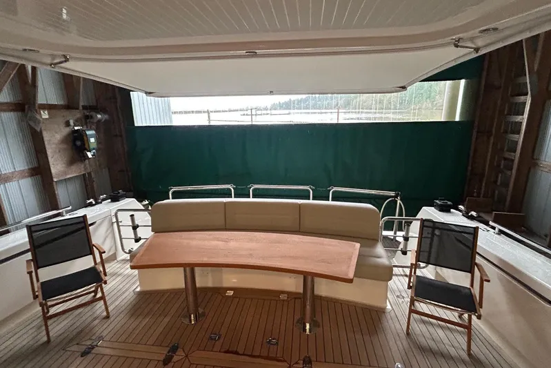  Yacht Photos Pics 2020 Maritimo M64 yacht interior with seating, table, and chairs in a covered area.