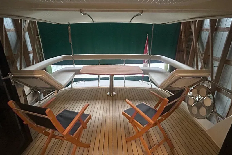 Yacht Photos Pics Luxury deck seating on 2020 Maritimo M64 yacht with wooden chairs and table.