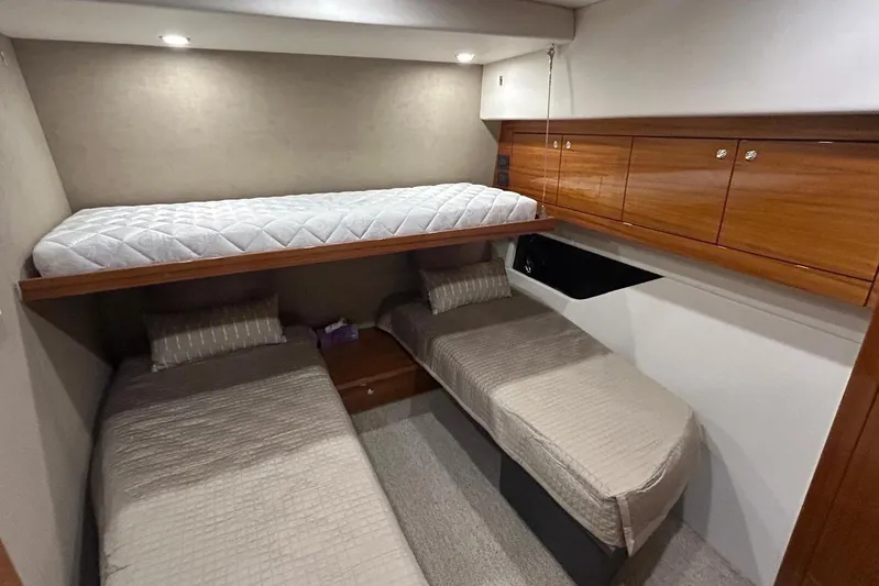  Yacht Photos Pics 2020 Maritimo M64 yacht cabin with three beds and wooden storage cabinets.