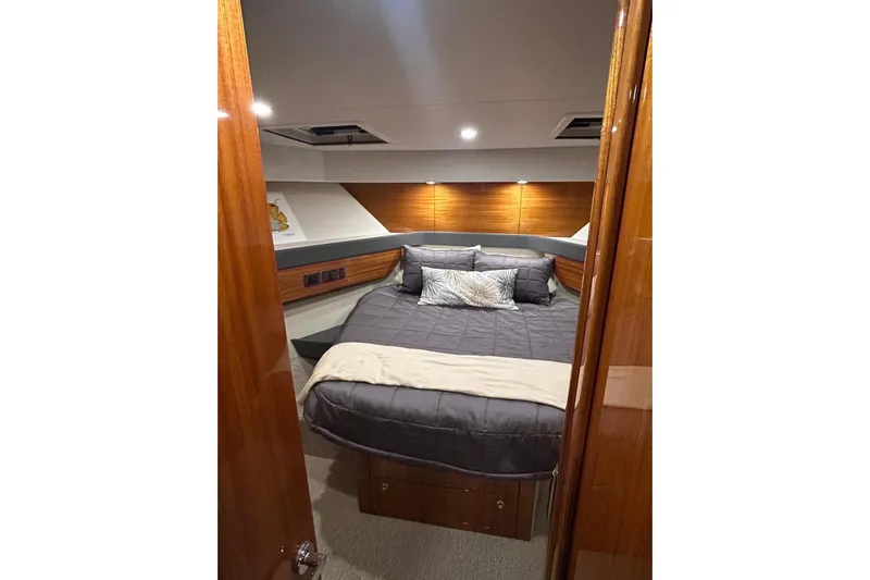  Yacht Photos Pics Luxurious bedroom interior of 2020 Maritimo M64 yacht with elegant bedding and wood accents.