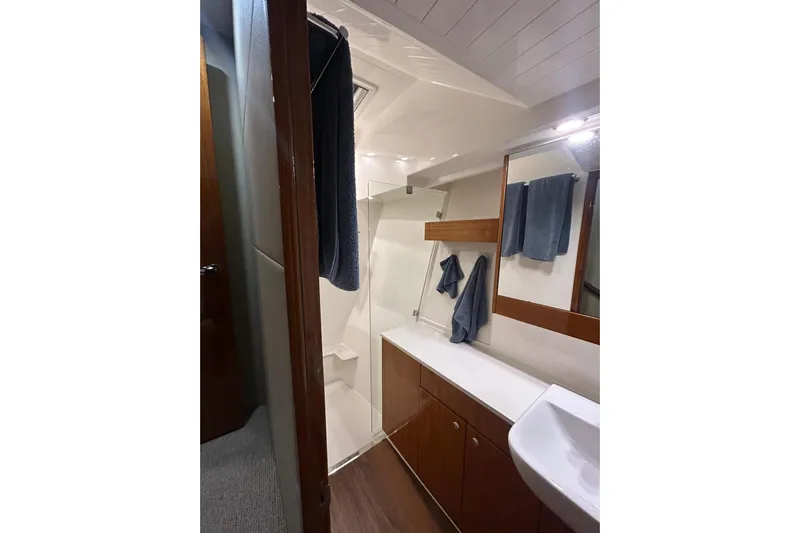  Yacht Photos Pics Luxurious bathroom interior of 2020 Maritimo M64 yacht with modern fixtures and wooden cabinetry.