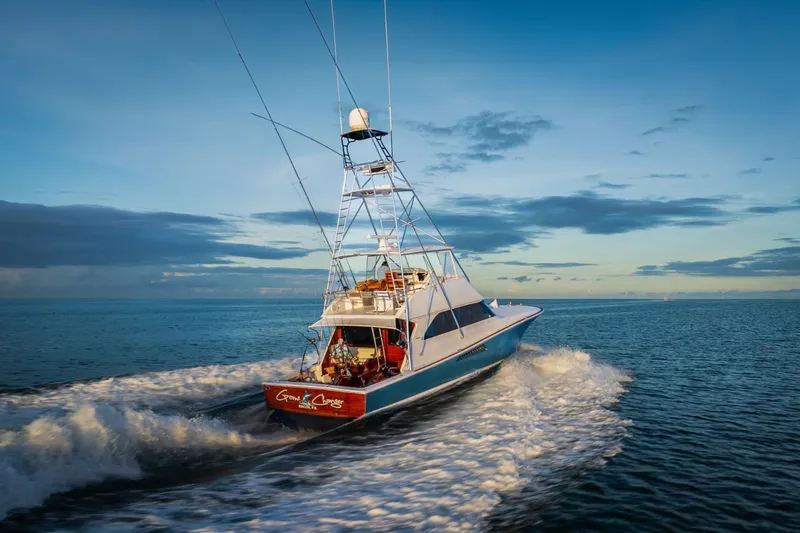  Yacht Photos Pics 2002 Viking 55 Convertible yacht cruising on open water at sunset.