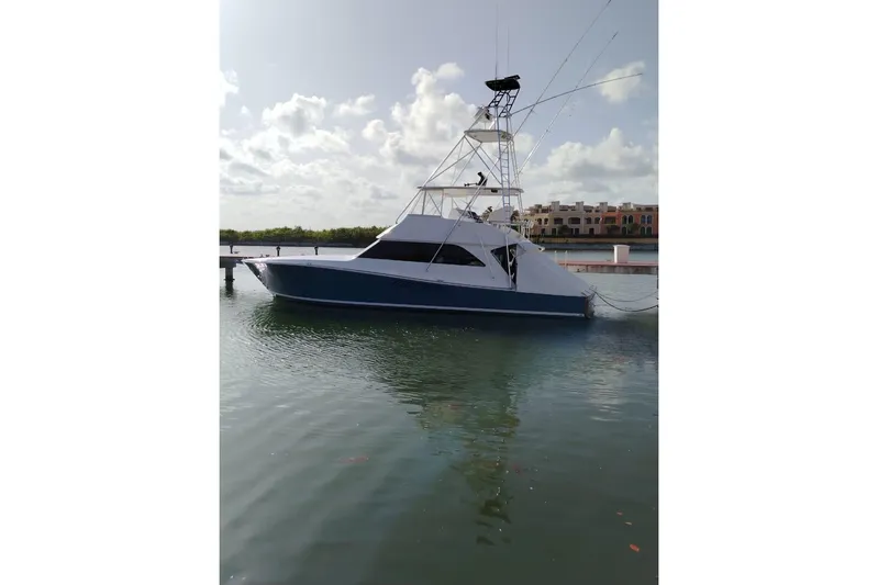 Yacht Photos Pics 2002 Viking 55 Convertible yacht docked in calm waters under a partly cloudy sky.