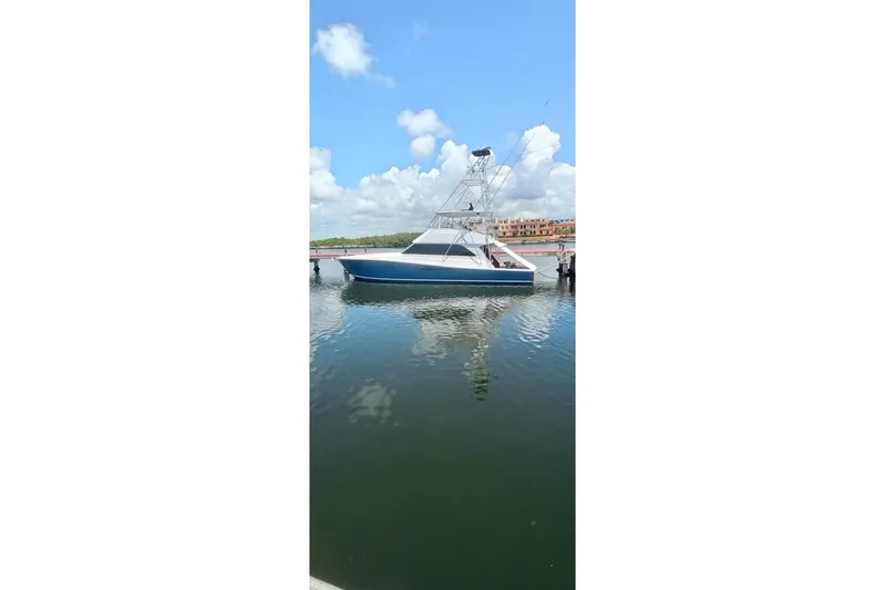  Yacht Photos Pics 2002 Viking 55 Convertible yacht docked on calm water under a clear blue sky.