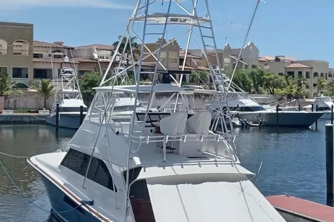  Yacht Photos Pics 2002 Viking 55 Convertible yacht docked in a marina, featuring a tall tower.