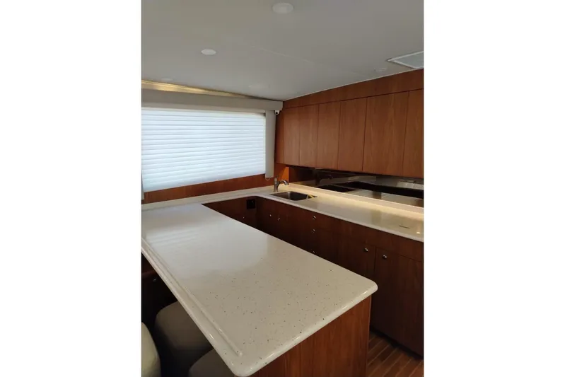  Yacht Photos Pics Luxurious kitchen interior of 2002 Viking 55 Convertible yacht with sleek countertops and wooden cabinetry.
