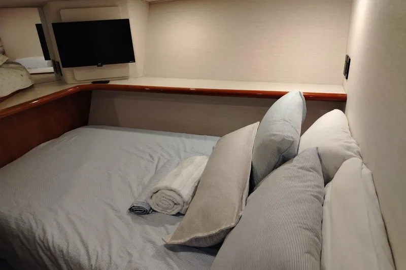  Yacht Photos Pics Cozy bedroom in 2002 Viking 55 Convertible yacht with TV and plush pillows.