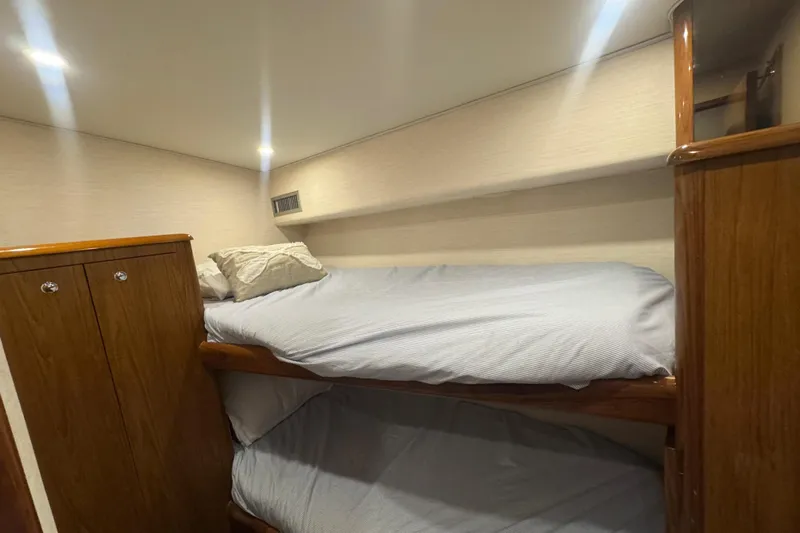  Yacht Photos Pics Interior of 2002 Viking 55 Convertible yacht with wooden bunk beds and soft lighting.