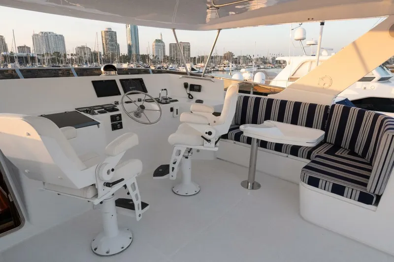 Ok'd By Dad Yacht Photos Pics 2001 Mikelson 61 Yachtfisher helm with seating, steering wheel, and city skyline view.