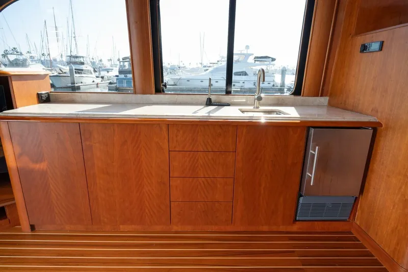 Ok'd By Dad Yacht Photos Pics Luxurious wooden interior of 2001 Mikelson 61 Yachtfisher with sleek countertop and marina view.