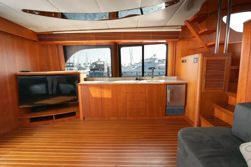 Ok'd By Dad Yacht Photos Pics Luxurious 2001 Mikelson 61 Yachtfisher interior with wood finish, kitchenette, and marina view.