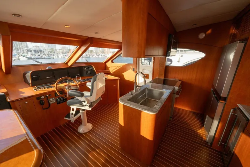 Ok'd By Dad Yacht Photos Pics Interior of 2001 Mikelson 61 Yachtfisher with helm, kitchen, and wooden flooring.