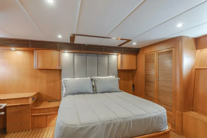 Ok'd By Dad Yacht Photos Pics Luxurious bedroom interior of 2001 Mikelson 61 Yachtfisher with wood paneling and cozy bedding.