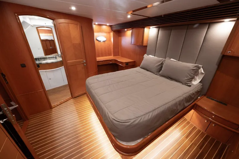 Ok'd By Dad Yacht Photos Pics Luxurious bedroom interior of 2001 Mikelson 61 Yachtfisher with wood paneling and cozy bedding.