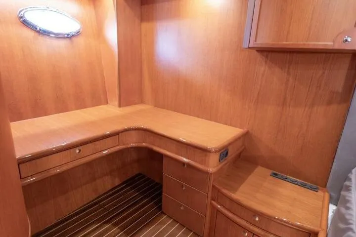 Ok'd By Dad Yacht Photos Pics Luxurious wooden interior of a 2001 Mikelson 61 Yachtfisher, featuring a built-in desk and drawers.