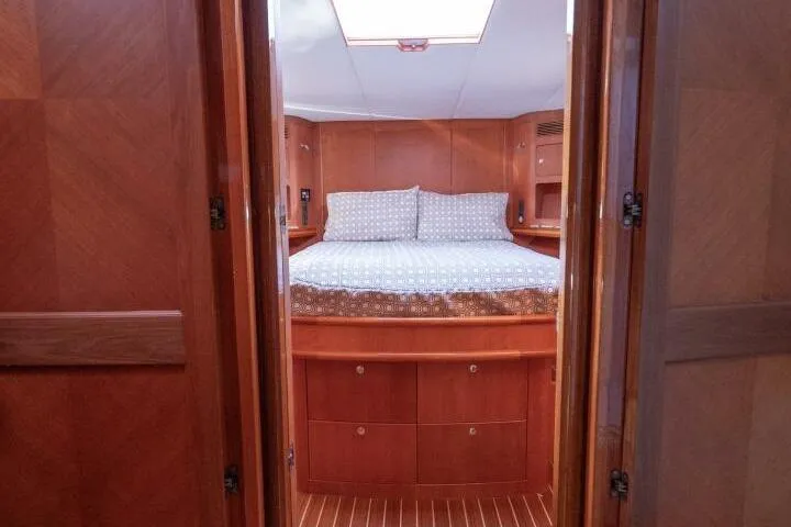 Ok'd By Dad Yacht Photos Pics Interior cabin of 2001 Mikelson 61 Yachtfisher with wooden finish and cozy bedding.