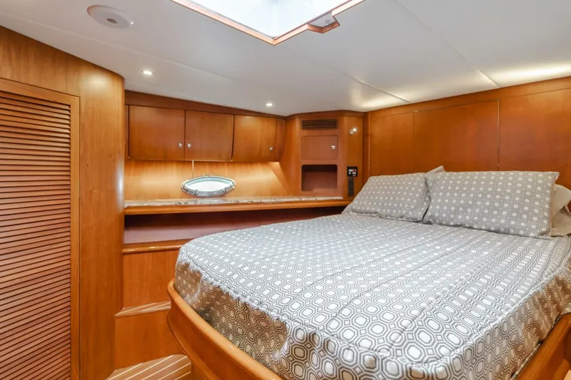 Ok'd By Dad Yacht Photos Pics Luxurious cabin interior of 2001 Mikelson 61 Yachtfisher with wood paneling and cozy bedding.