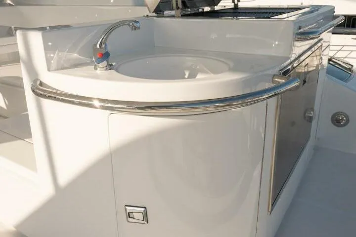 Ok'd By Dad Yacht Photos Pics Luxury sink area on 2001 Mikelson 61 Yachtfisher, featuring sleek design and chrome fixtures.