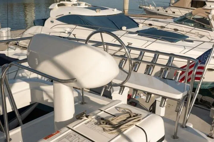 Ok'd By Dad Yacht Photos Pics 2001 Mikelson 61 Yachtfisher helm with marina view and American flag.