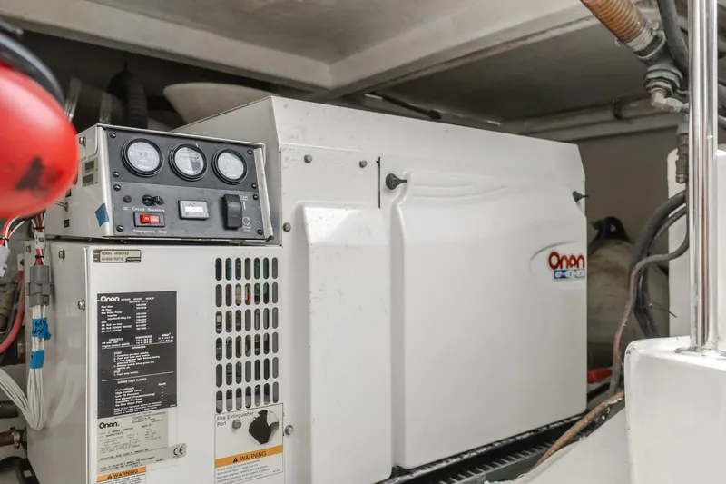Ok'd By Dad Yacht Photos Pics Onan generator in 2001 Mikelson 61 Yachtfisher engine room, showcasing control panel and wiring.