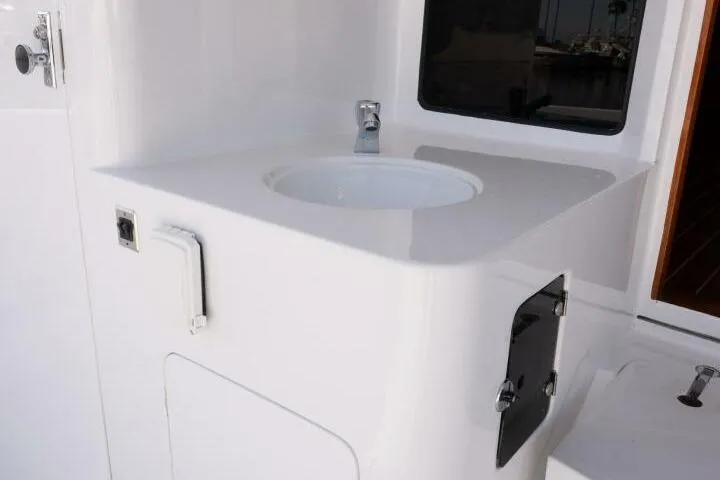 Ok'd By Dad Yacht Photos Pics White sink area on 2001 Mikelson 61 Yachtfisher, featuring modern fixtures and storage.