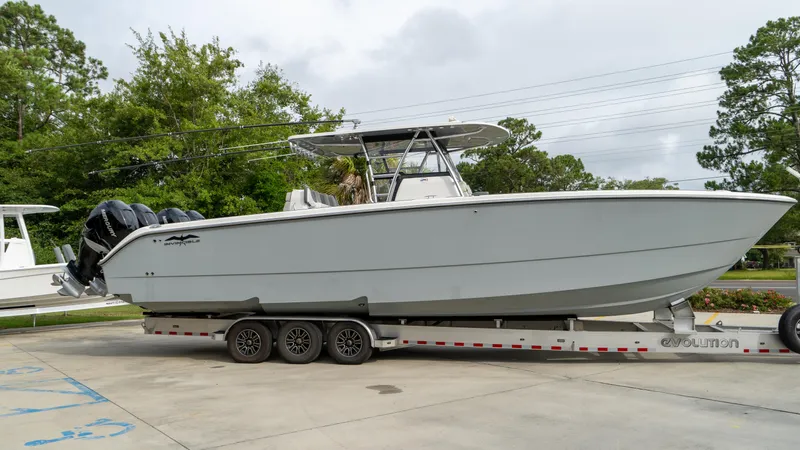  Yacht Photos Pics 2021 Invincible 37 Catamaran on trailer, parked outdoors, with triple outboard engines.