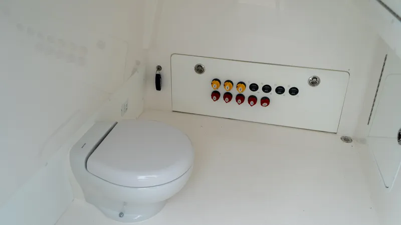  Yacht Photos Pics 2021 Invincible 37 Catamaran interior with toilet and control panel.