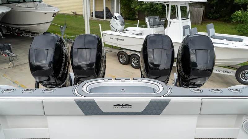  Yacht Photos Pics 2021 Invincible 37 Catamaran with four powerful outboard engines, docked near other boats.