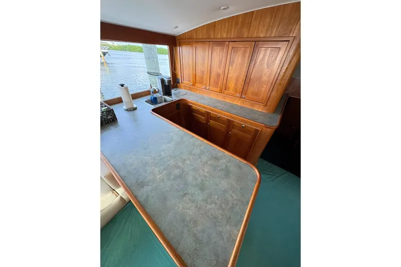Sea Hag Yacht Photos Pics Luxurious wooden kitchen interior of 2008 Blackwell Custom Carolina 61 yacht, featuring ample cabinetry.