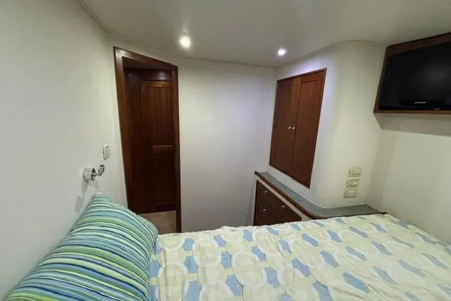 Sea Hag Yacht Photos Pics Interior cabin of 2008 Blackwell Custom Carolina 61, featuring bed, wooden door, and TV.