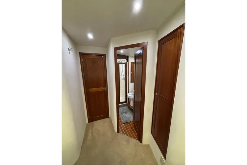 Sea Hag Yacht Photos Pics Interior hallway of 2008 Blackwell Custom Carolina 61 yacht, featuring wooden doors and carpeted floor.